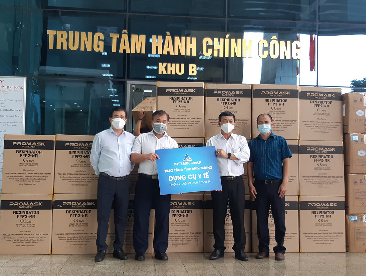 Đại diện Tập đoàn Đất Xanh trao tặng khẩu trang y tế N95 và bộ đồ bảo hộ cho ông Nguyễn Văn Lộc, Chủ tịch Ủy ban MTTQ tỉnh Bình Dương